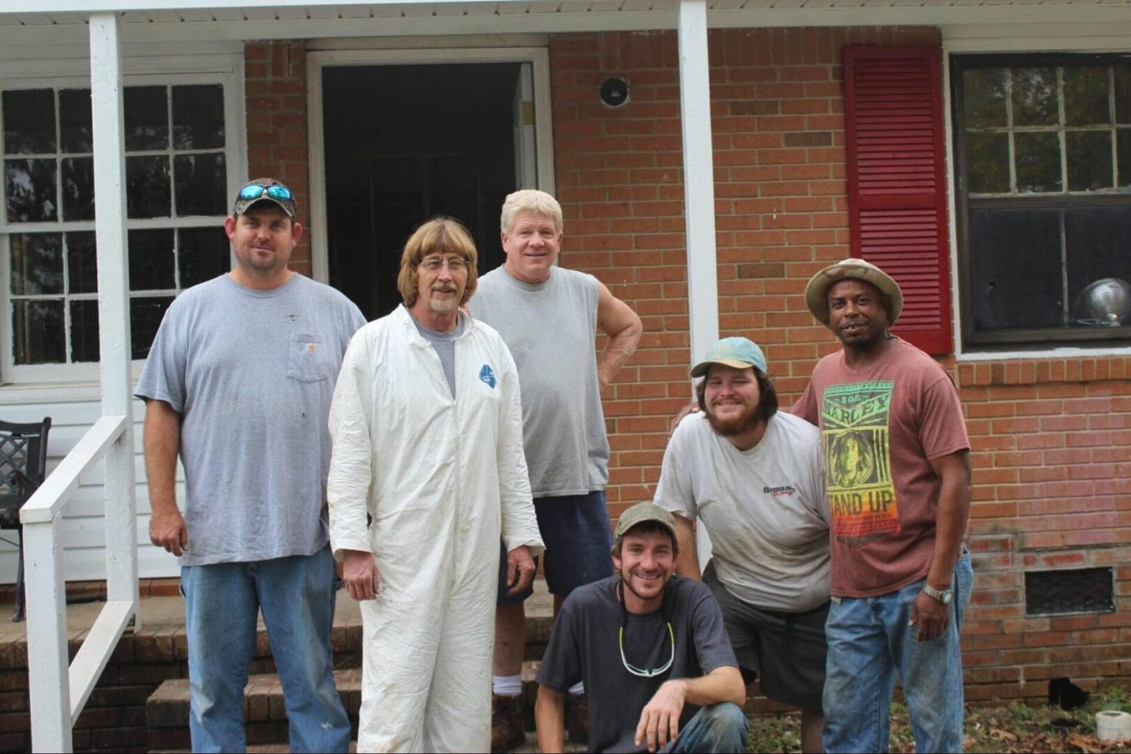 A group of people standing in front of a house.