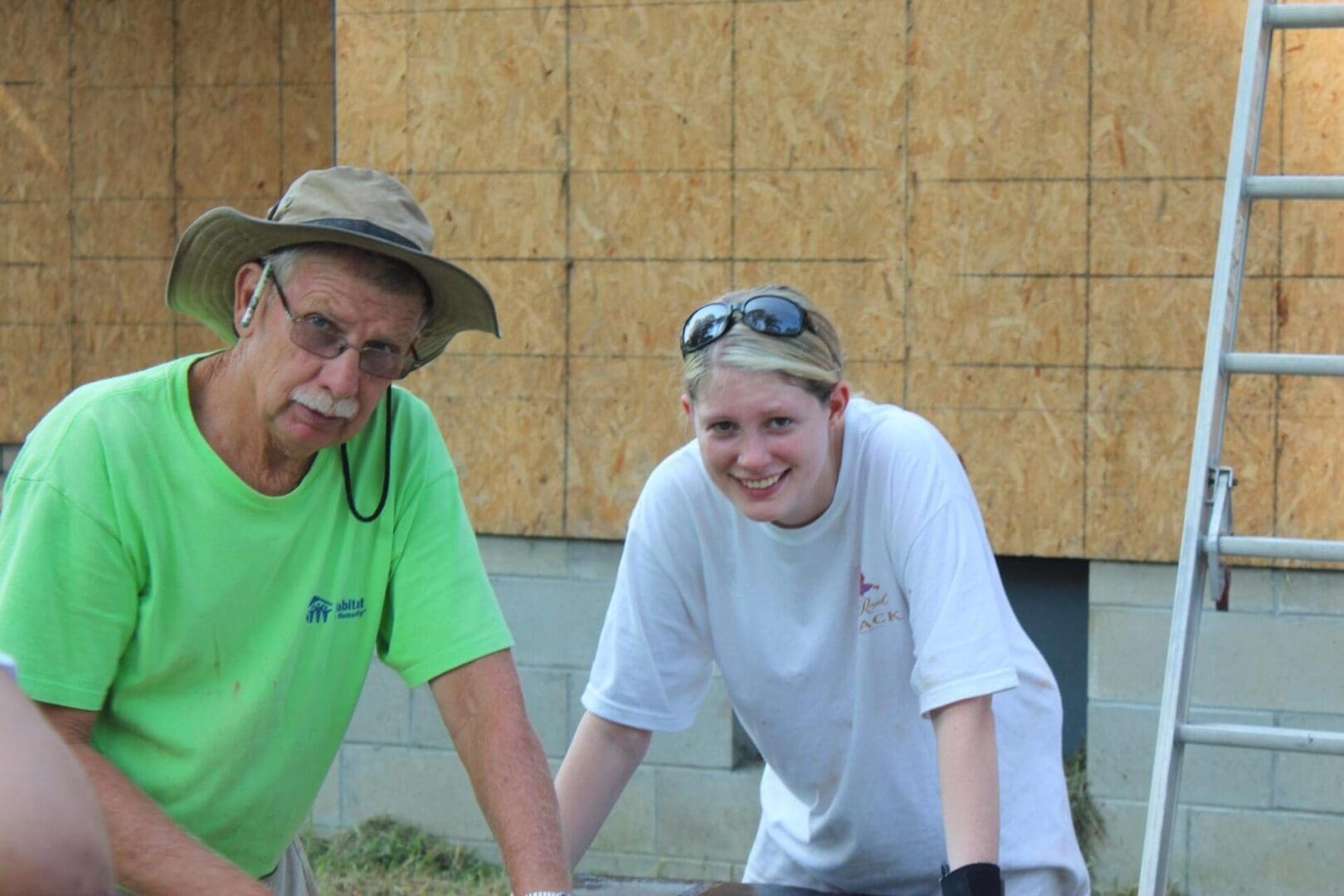 A man and woman working on something outside.