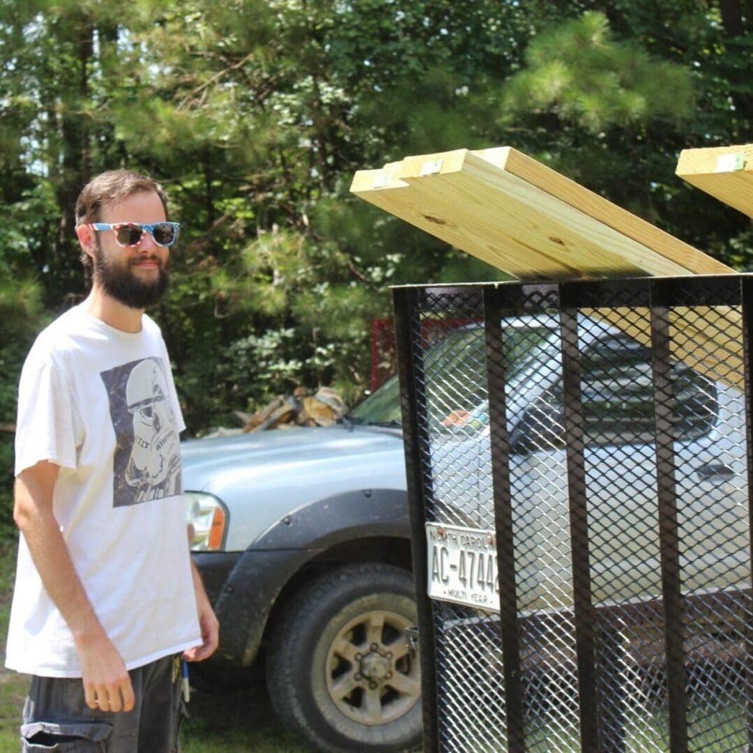 A man standing next to a trash can.